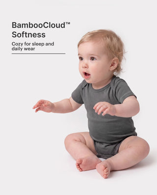 A four-piece set of plain white modal baby rompers folded together, the everyday layer that is outgrown fastest