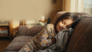 Young child holding a well-loved comfort blanket against her cheek