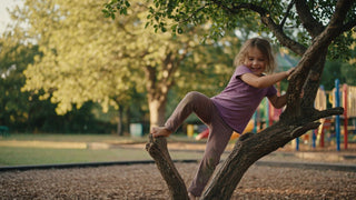 Active young child climbing at the playground in stretchy play pants