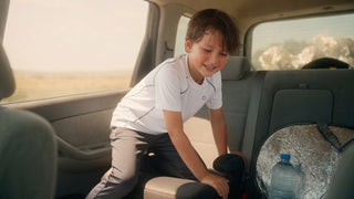 Child in cooling quick-dry activewear climbing into a hot car on a summer road trip