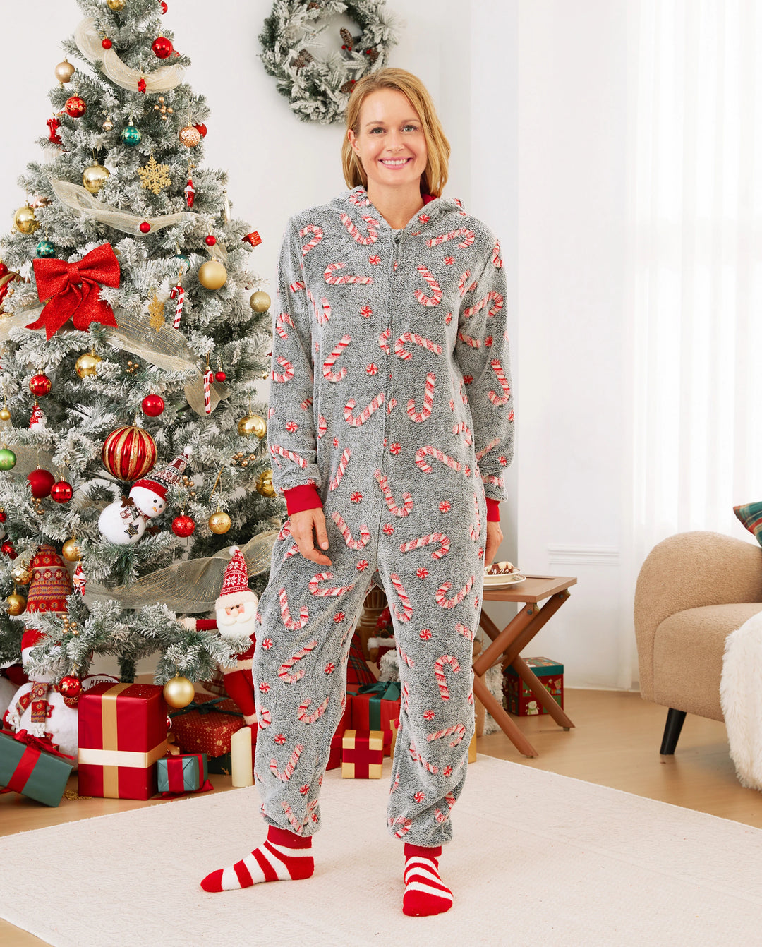 Pijamas de una pieza a juego con trajes navideños, estampado de bastón de caramelo (brillan en la oscuridad) y calcetines navideños negros.