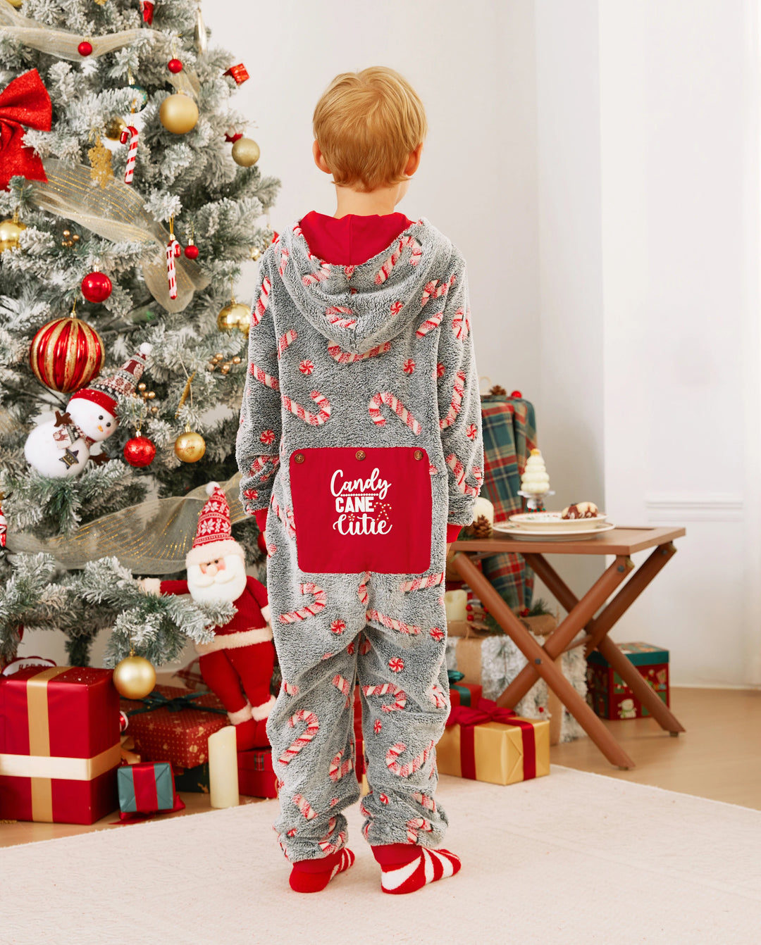 Pijamas de una pieza a juego con trajes navideños, estampado de bastón de caramelo (brillan en la oscuridad) y calcetines navideños negros.