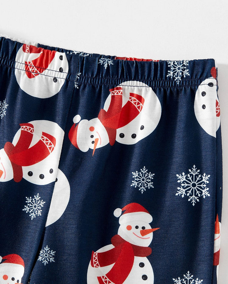 Pijamas familiares a juego con estampado de letras y muñeco de nieve navideño, mangas raglán y calcetines navideños en bloques de color.