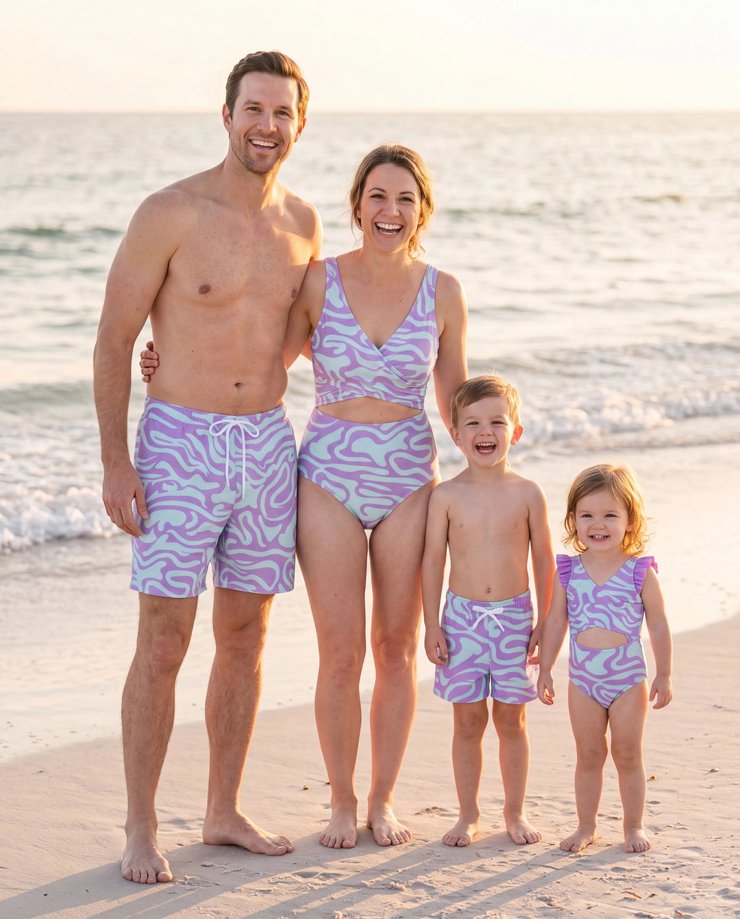 Familienpassende, trendige Badehose mit lila und blauem Wellendruck oder einteiliger Badeanzug mit Taillenausschnitt lila