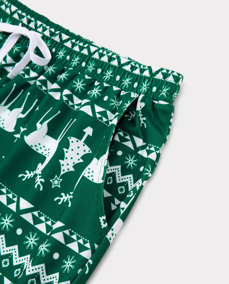 Conjunto de pijama familiar navideño con renos que brillan en la oscuridad, pantalones con estampado completo y calcetines navideños de color verde negruzco.
