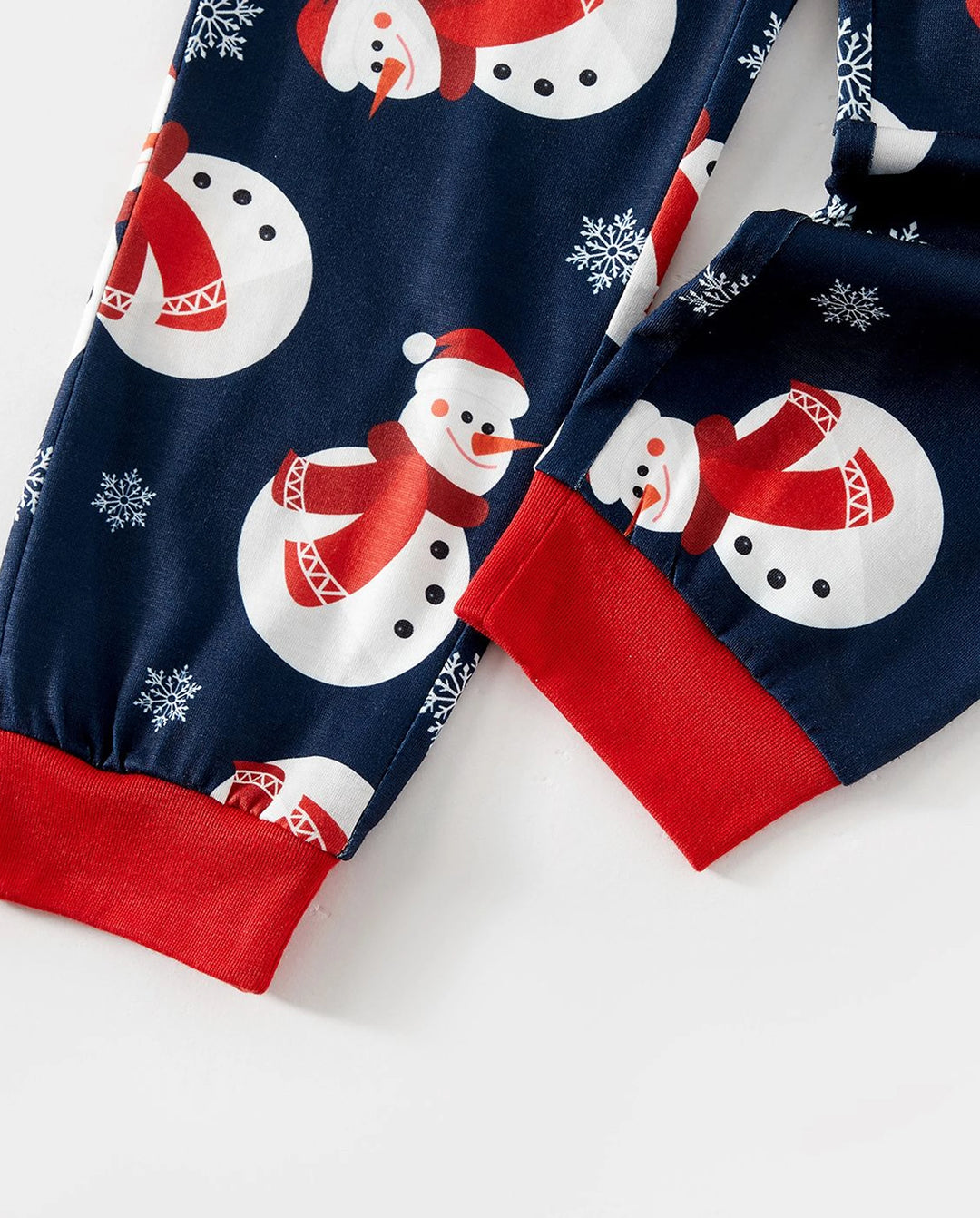 Pijamas familiares a juego con estampado de letras y muñeco de nieve navideño, mangas raglán y calcetines navideños en bloques de color.