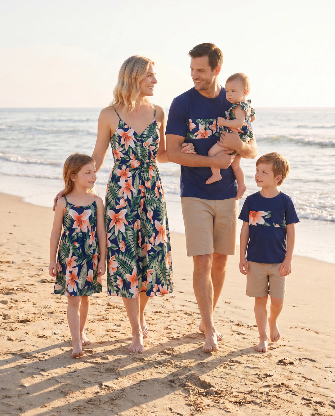 Conjuntos familiares a juego: camisetas de manga corta con paneles florales o vestidos midi con cuello en V y tirantes finos con estampado floral completo y broche oculto en azul real.