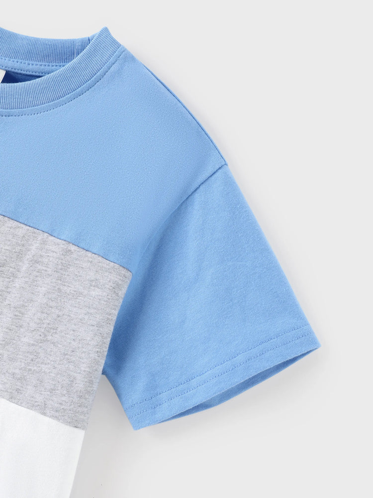 Tenues familiales assorties : robe à imprimé floral bleu et blanc ou t-shirt colorblock, ensemble vacances d'été bleu