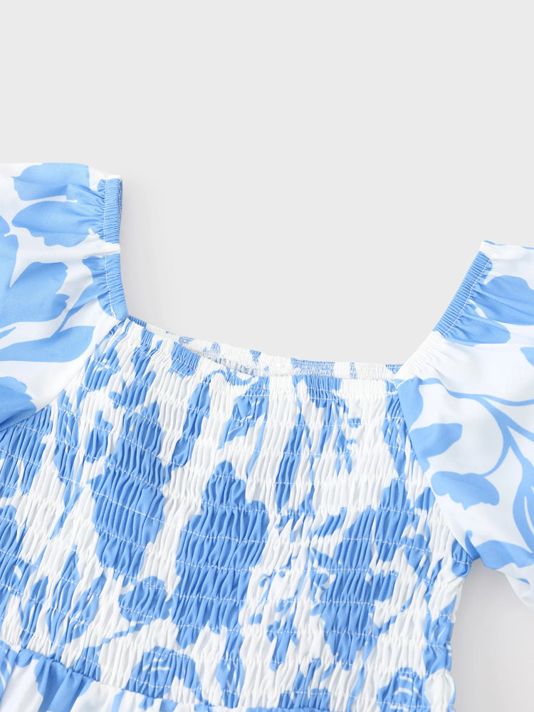 Tenues familiales assorties : robe à imprimé floral bleu et blanc ou t-shirt colorblock, ensemble vacances d'été bleu