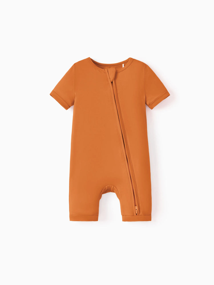 Snug-fitting bamboo baby footed onesie with two-way zipper and anti-slip grips, orange.